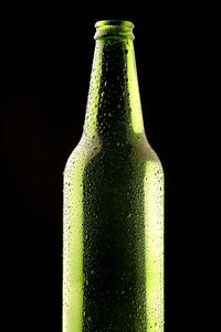 Close-up of green bottle against black background