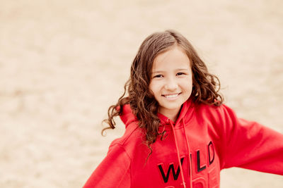 Happy girl running along the beach. girl in a red hoodie