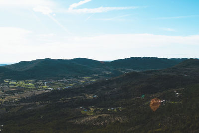 Scenic view of field and mountains against sky