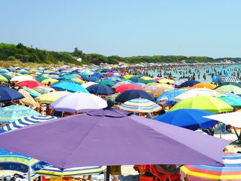 Colorful beach umbrellas against clear blue sky