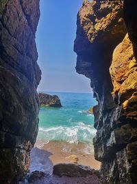 Rock formation on beach against sky