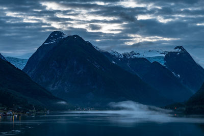 Scenic view of lake by mountains against sky