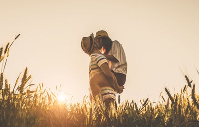 Man standing on field against sky during sunset