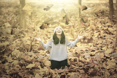 Full length of woman standing on field during autumn