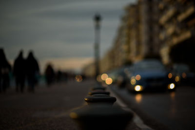 Close-up of electric lamp on city street against sky