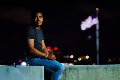 Portrait of young man standing at night