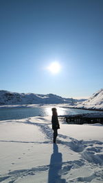 Man standing on snowcapped mountain against sky