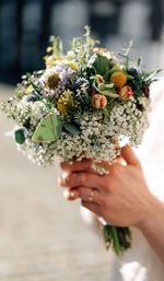 Midsection of man holding bouquet