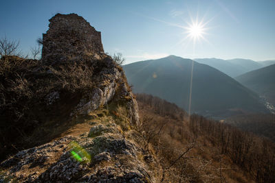 Scenic view of mountains against bright sun