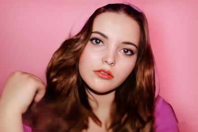 Portrait of beautiful woman against pink background