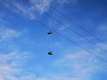 Low angle view of power lines against blue sky