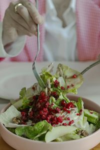 Close-up of hand holding fresh salad in bowl