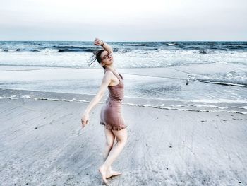 Full length of woman standing on beach