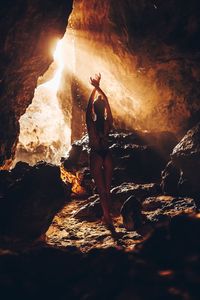 Rear view of woman standing on rock