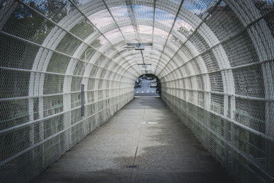 Arched walkway with metal wire mesh over highway for pedestrians