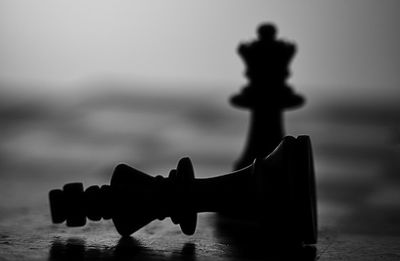 Close-up of silhouette figurine on table against sea