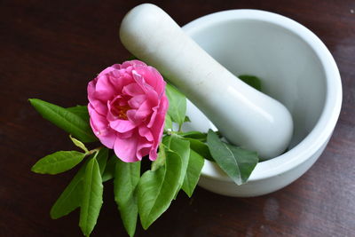 Close-up of pink flower in mortar and pestle on table