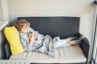 High angle view of boy sleeping on sofa at home