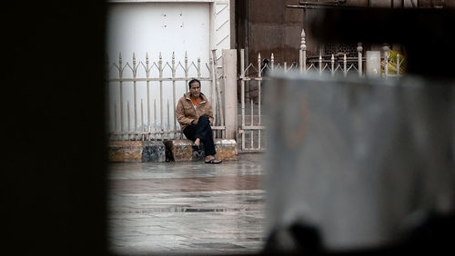 Full length of man standing on sidewalk