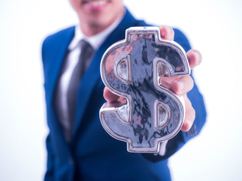 Close-up of man holding camera over white background