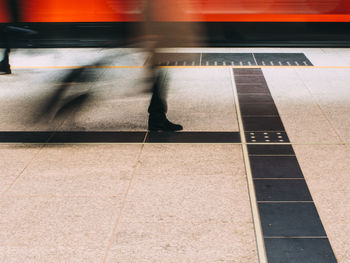 Low section of man standing on railroad station platform