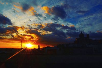 Silhouette buildings against sky during sunset