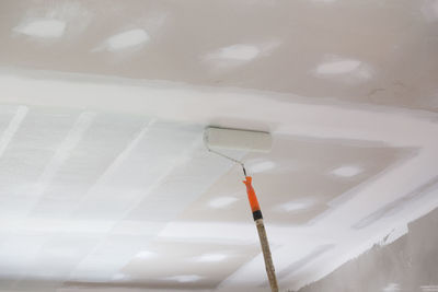 Low angle view of paintbrushes on wall