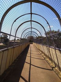 Footbridge over footpath against sky