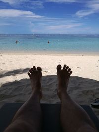 Low section of people relaxing on beach