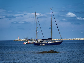 Sailboat sailing on sea against sky