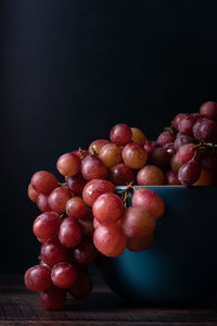 Close-up of grapes on table against black background