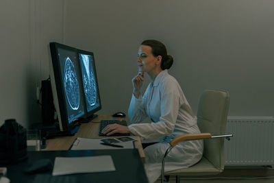 Young woman using mobile phone while sitting at home