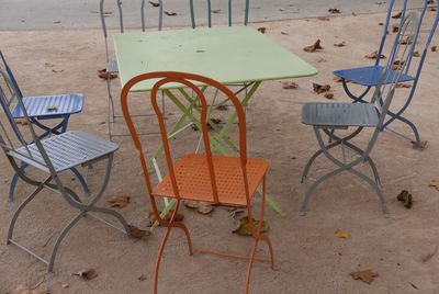 Empty chairs and table at sidewalk cafe