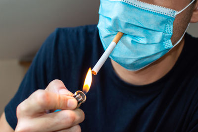 Close-up of man holding burning candle