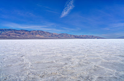 View of badwater basin at death valley national park against blue sky