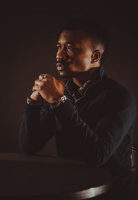 Portrait of young man against black background