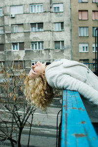 A young woman leaning over a fence