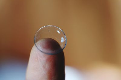 Close-up of hand holding contact lens