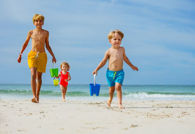 Full length of shirtless man standing at beach