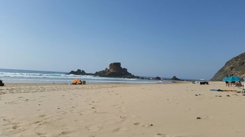 Scenic view of beach against blue sky