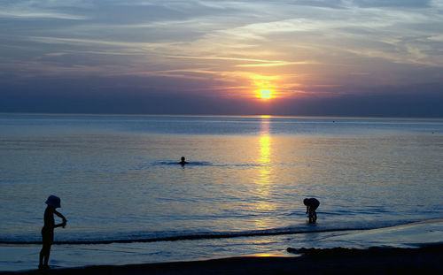 Silhouette of people standing on beach