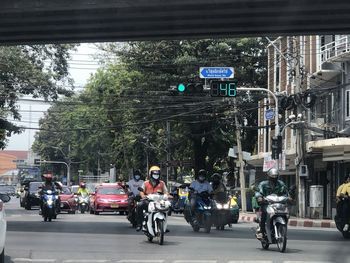 People riding motorcycle on road in city