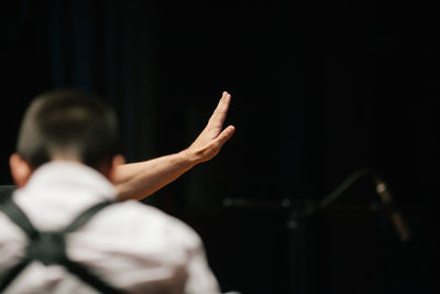 Cropped hand gesturing stop with man in foreground