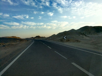 Empty road along landscape against sky