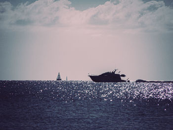 Sailboats sailing on sea against sky