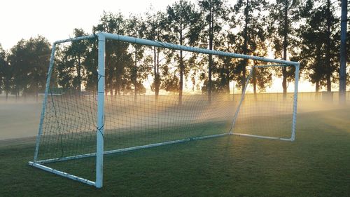 Goal post on soccer field during sunrise