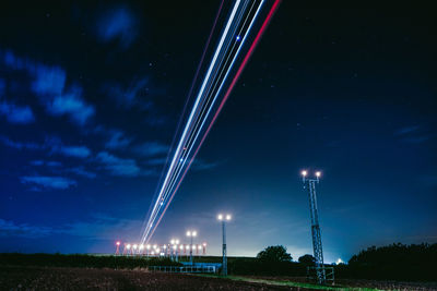 Low angle view of illuminated lights against sky at night