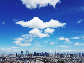 Panoramic view of modern buildings against blue sky
