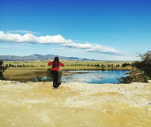 Rear view of woman on water against sky