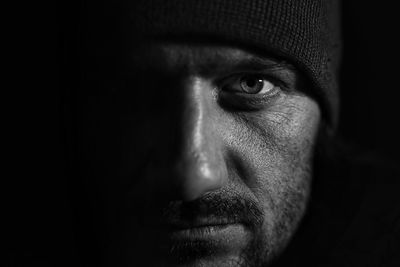 Close-up portrait of man against black background